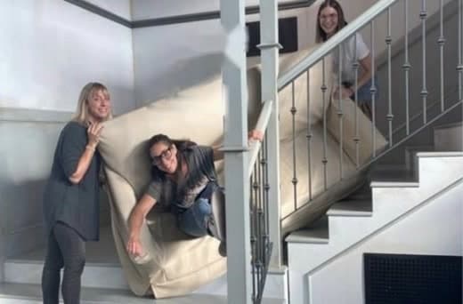 Roomeeo’s three co-founders, Debbie, Alana and Andy, carrying a couch up a narrow staircase